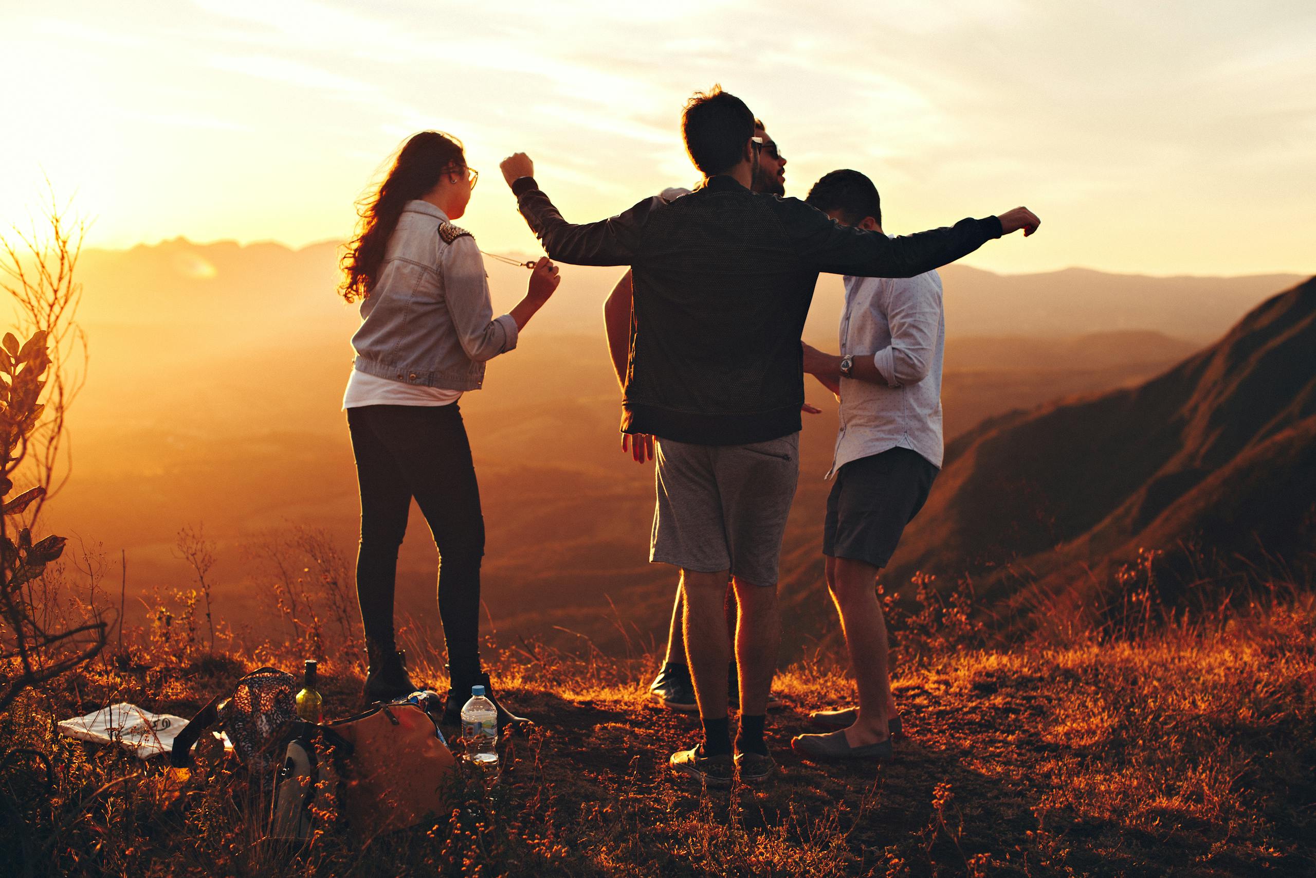 Joyful group of adults enjoying a sunset view of a mountainous landscape