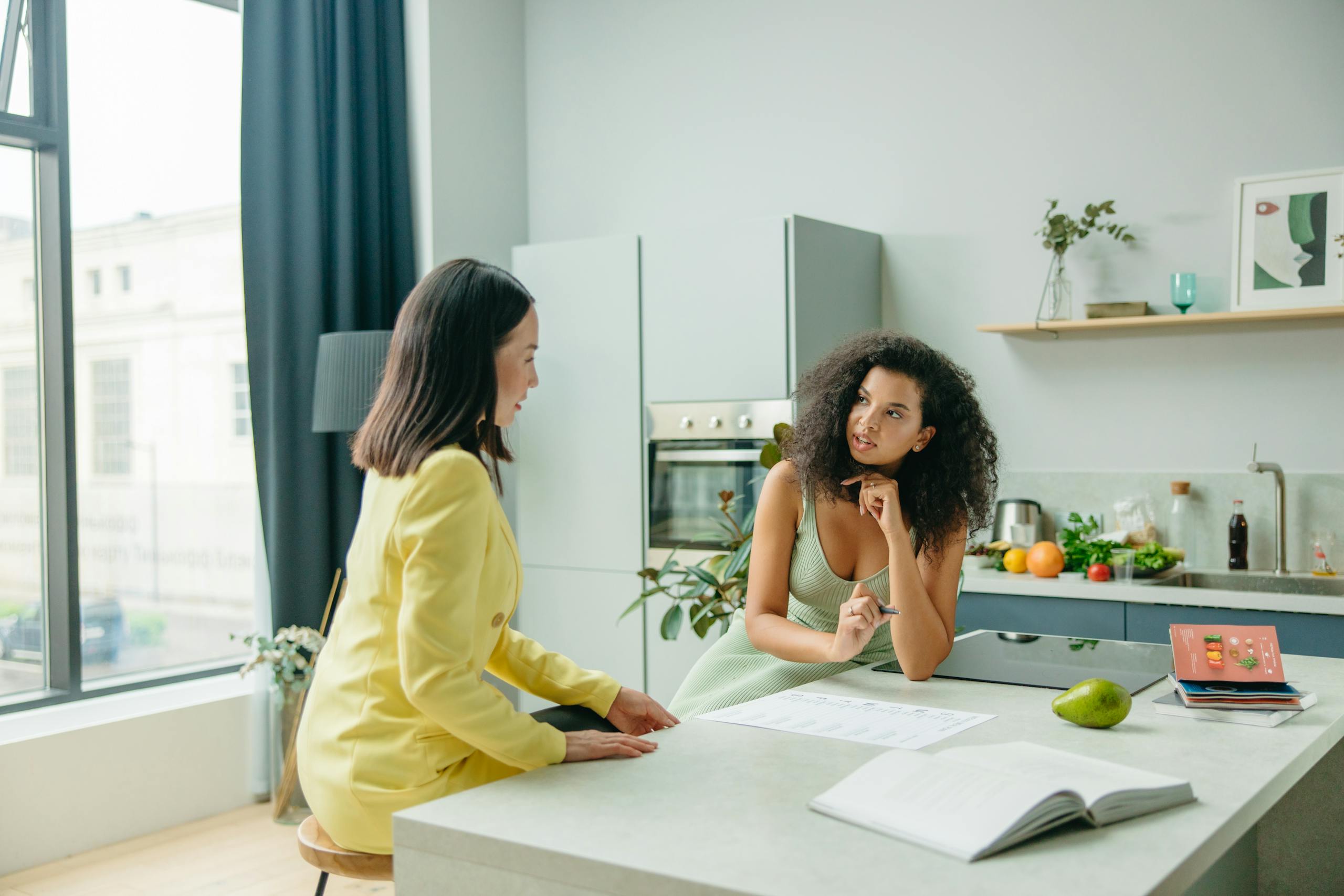 Coach and client discussing topics while in client's home kitchen