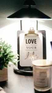 warmly lit desk lamp with inspirational clipboard and decor that says Love Your Life for a cozy ambiance
